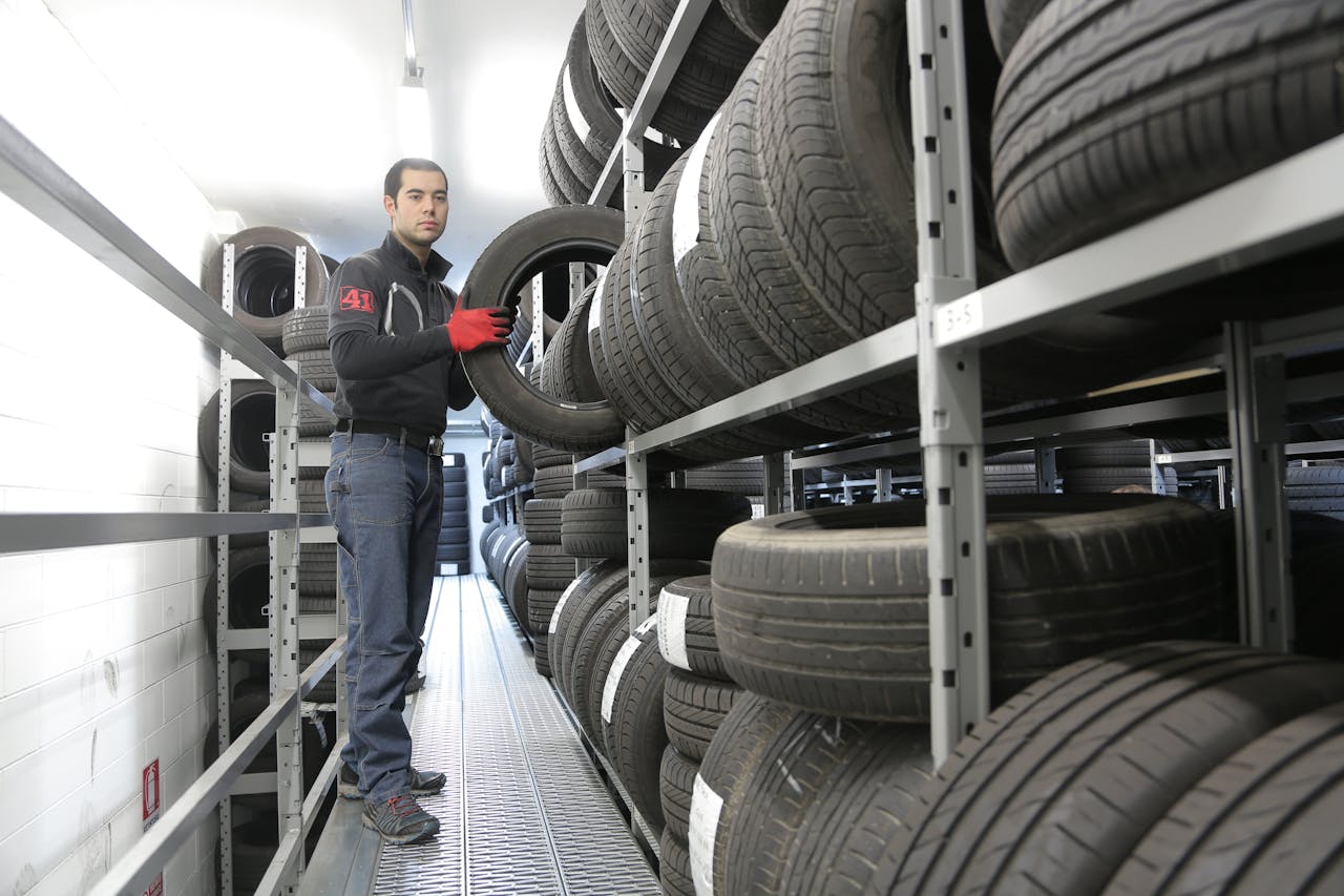 Man in Black Jacket Standing Beside Black Tires